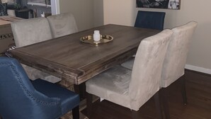 A dining room with a wooden table, six chairs, a chandelier, and a horse painting on the wall. - Inviting/Cozy Home in Medical Center - Beautiful home to stay!!  (Houston)