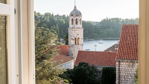 A view of a bell tower and a river from a window.