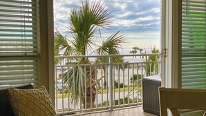A balcony with a view of palm trees and a road. - The Turtles Escape (Destin)