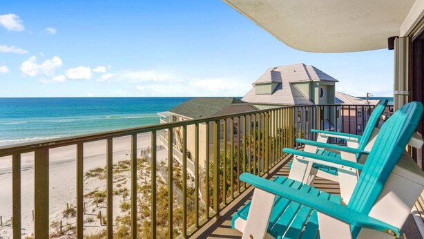 A balcony with turquoise chairs overlooking a beach and ocean. - Commodore 410 (Panama City Beach)