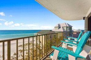 A balcony with turquoise chairs overlooking a beach and ocean. - Commodore 410 (Panama City Beach)
