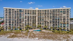A large, multi-story hotel with numerous balconies, a central pool, and a beach view. - Commodore 410 (Panama City Beach)