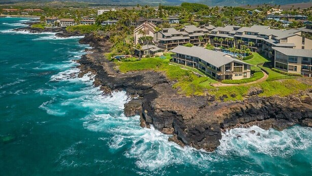 A coastal resort with ocean views, a rocky shoreline, and modern buildings. - Makahuena 5103 Oceanfront By Suite Paradise (Koloa)