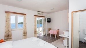 Una habitación de hotel con cama, escritorio, silla y vista al mar.