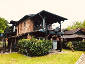 A two-story house with a balcony and a covered porch. - Ferienwohnung mit Meerblick, Balkon und Kamin OFC 06 - Nr. 3 Ferienwohnung mit Meerblick, Balkon und (Rerik)