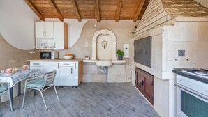 Una cocina compacta con armarios blancos, un microondas, un fregadero y un horno empotrado.