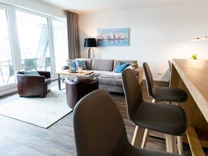 A modern living room with a sofa, two armchairs, a coffee table, and a dining area. - Hafenspitze App. 34, Deutschland (Wismar)