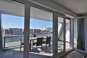 A modern room with large windows, a dining table, and chairs.
