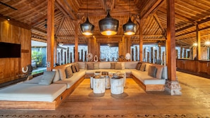A spacious lounge area with a wooden ceiling, a large sofa set, and a central coffee table. - Palatial Wooden Villa, 4br, Lovina (Banjar)