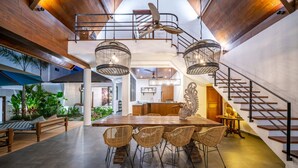 A spacious living area with a wooden dining table, wicker chairs, and a staircase. - Contemporary Private Villa, 4 BR, Canggu With Staff (Canggu)