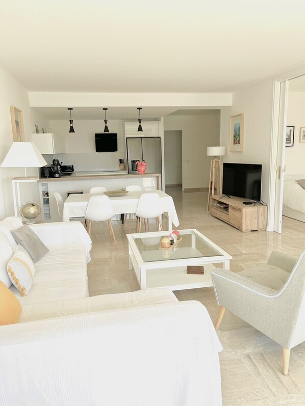 A modern living room with a white sofa, a glass coffee table, and a TV stand. - Pierre Longue,3 bedrooms apartment with sea view in bulding with swimming pool (Cannes)