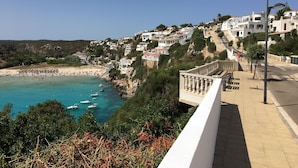 A coastal town with white buildings, a beach, and a promenade. - Modern apartment with a fantastic view Vistamar 3 (Cala en Porter)