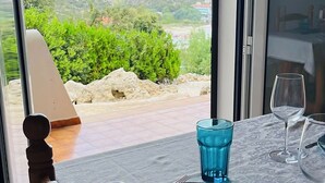 A dining table with a view of a landscape through a window. - Modern apartment with a fantastic view Vistamar 3 (Cala en Porter)