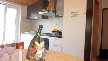 Een koelkast, een oven, een broodrooster, kookgerei, borden en bestek