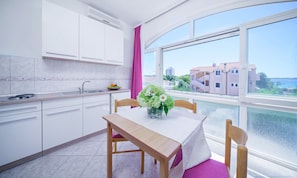 Enjoy meals at the dining table with a view of the surrounding buildings and greenery.