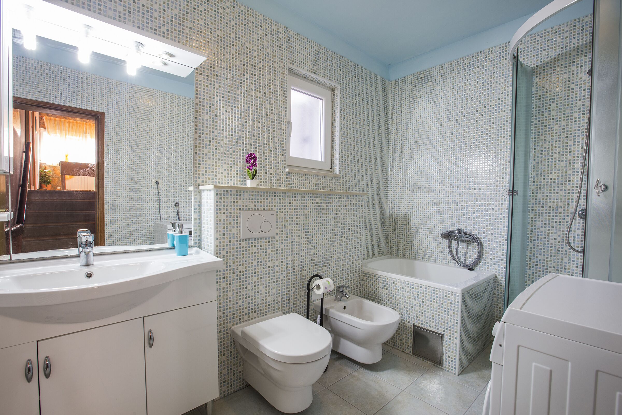 A bathroom with a toilet, bidet, bathtub, and a shower.
