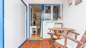 A room with a dining table and chairs, a window, and a door leading to another room. - Holiday Home "El Sombrerito 5" with Terrace & Wi-Fi (Caleta de Sebo)