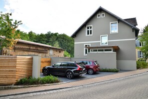 A modern two-story house with a garage, parked cars, and a brick pathway. - Landidyll Schwielowsee "Villa Siebenhaar" - Coziness at the Schwielowsee (Schwielowsee)