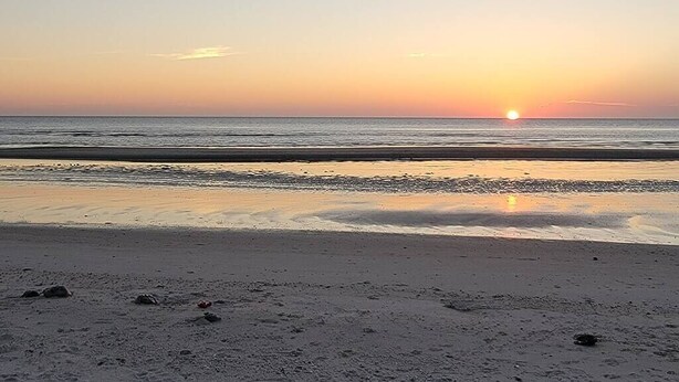A beach at sunset with a calm sea and a clear sky. - Renovated Ridgewood Bay House (Lower Township)