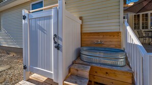 A wooden deck with a metal hot tub and a white gate. - Renovated Ridgewood Bay House (Lower Township)