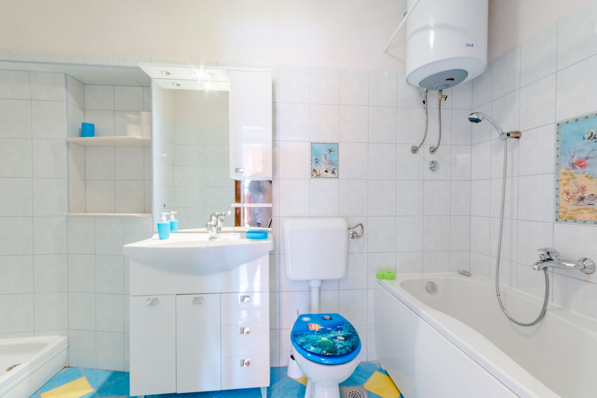 A bathroom with a white sink, toilet, bathtub, and a shower.