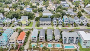 An aerial view of a coastal residential area with houses, a beach, and a pool complex. - Walk to Surfside Beach from This 4-Bedroom Condo w/ Resort Pool (Surfside Beach)