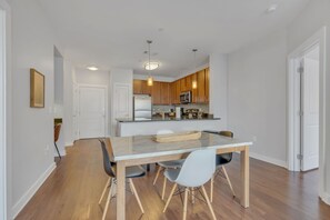 A modern kitchen with wooden cabinets, a central island, and pendant lighting.