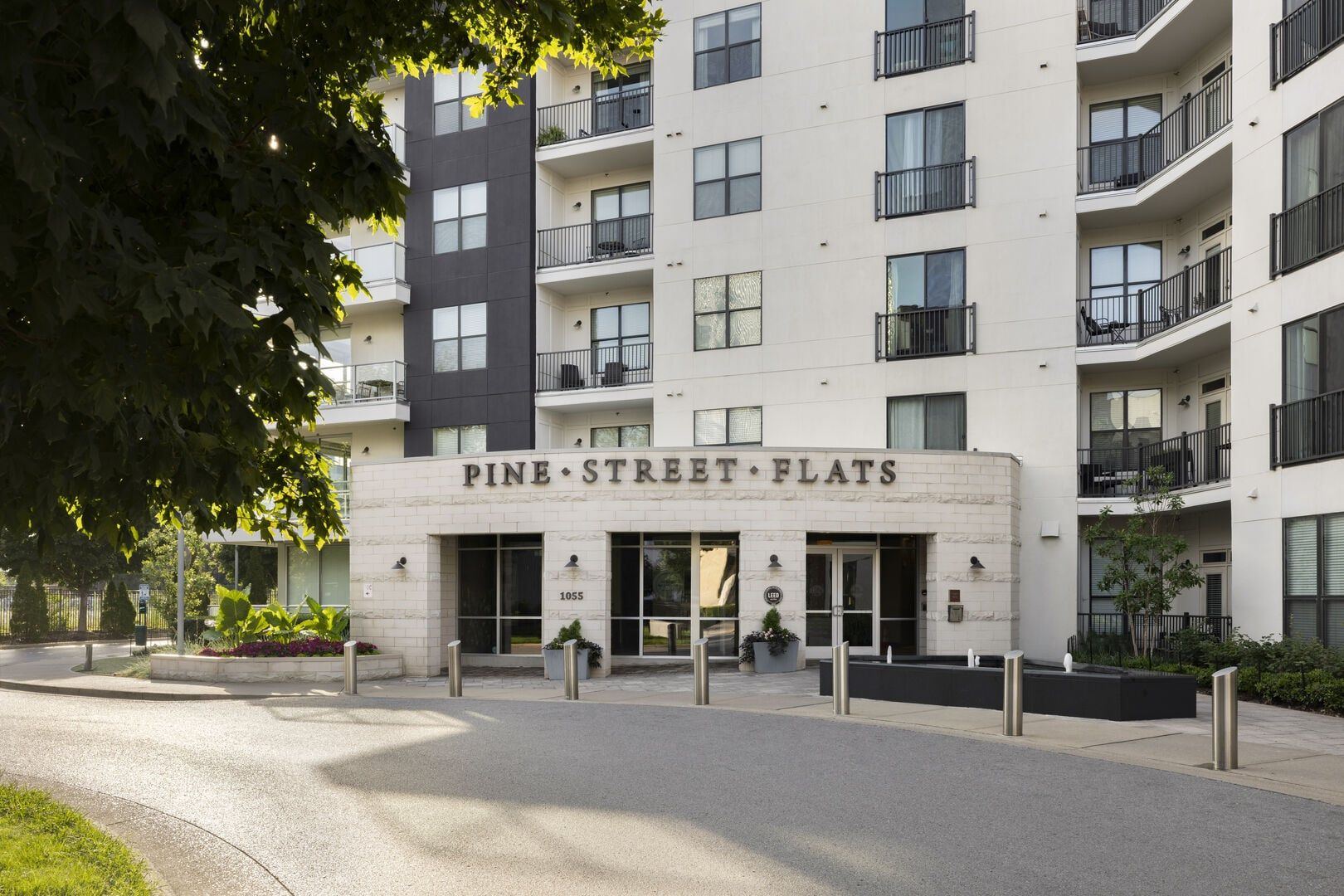 A multi-story building with the sign 'Pine Street Flats' indicating a residential complex.