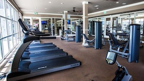 Una palestra con tapis roulant, macchinari per pesi e attrezzature per esercizi.