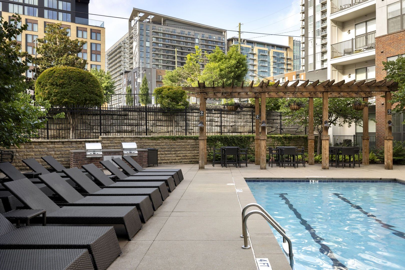 A poolside area with lounge chairs and a pergola.
