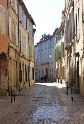 A cobblestone street lined with historic buildings, featuring arched windows and traditional facades. - Charming Renovated Apartment Near the Historic Center of Tarascon (Tarascon)