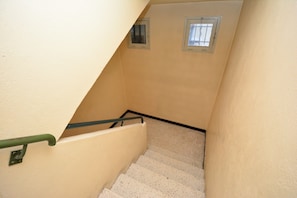 A narrow stairway with a green handrail and two small windows at the top. - Charming Renovated Apartment Near the Historic Center of Tarascon (Tarascon)