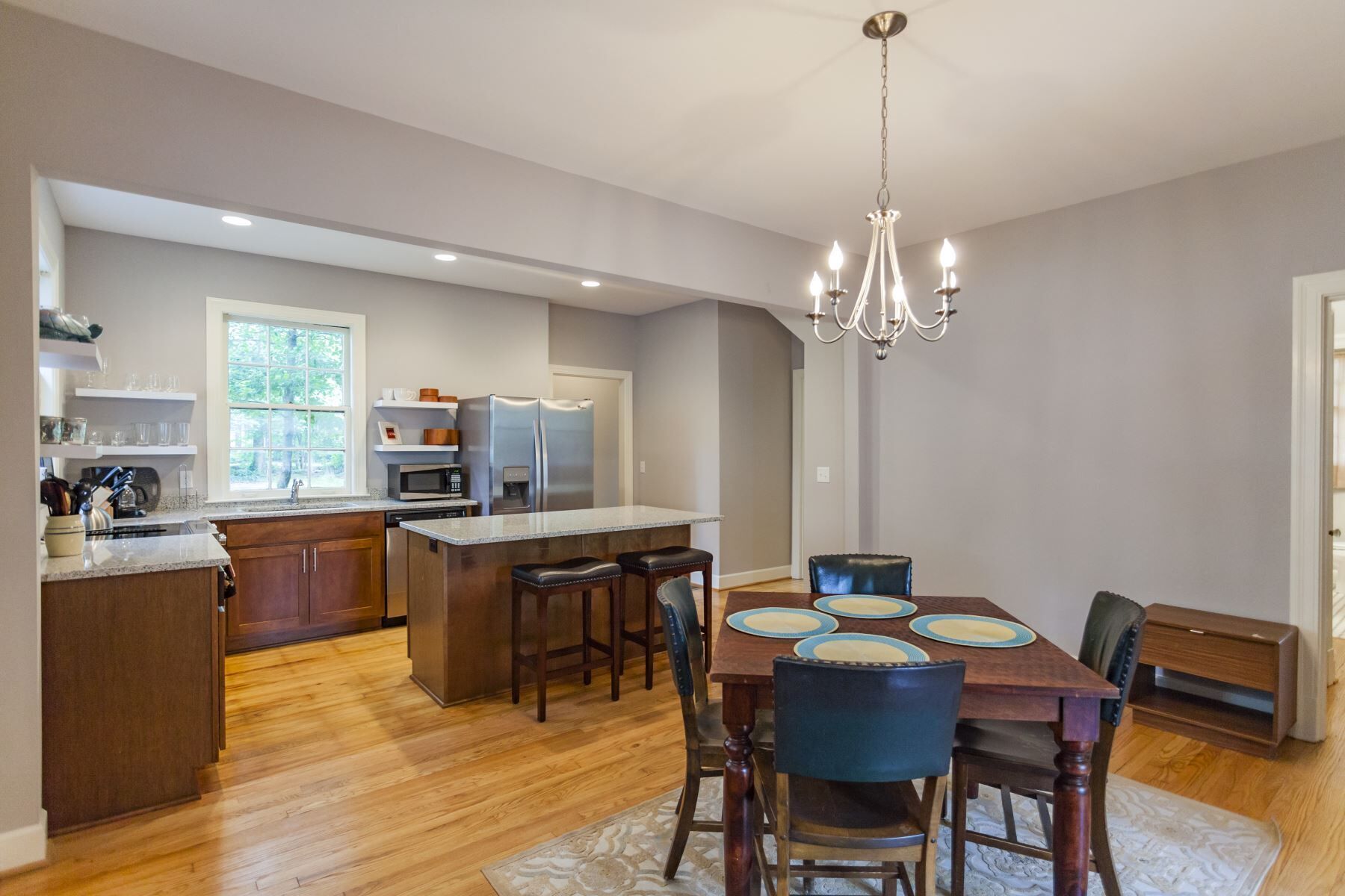 A modern kitchen with a central island, wooden cabinets, and stainless steel appliances.