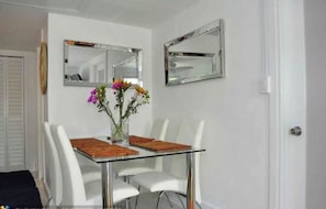 Enjoy meals in this dining area with a glass-top table and comfortable seating for four.