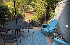 Relax in a serene outdoor space surrounded by lush greenery, featuring a round table and six comfortable chairs.