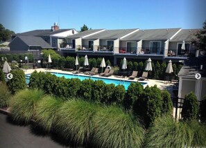 Relax by the pool surrounded by lush greenery and comfortable lounge chairs.