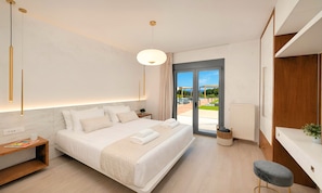 A modern hotel room with a large bed, bedside tables, a desk, and a view of an outdoor area.
