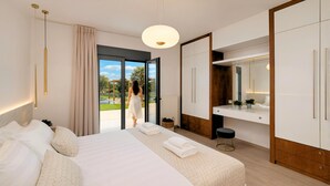 A modern hotel room with a large bed, a bathroom with a mirror, and a view of the outdoors. - Mistral Suite Heated Pool (Chania)