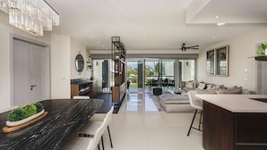 Una cocina moderna con encimera de mármol, comedor con banco y vistas al exterior.