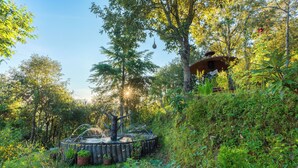 A garden with a wooden structure, possibly a gazebo, surrounded by lush greenery and trees. - Oak Climbing Resort (Dhari)