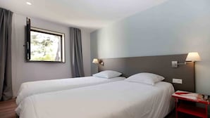 A hotel room with two single beds, a window with curtains, and two wall-mounted lamps. - Villa 6 persons golf de la Palmyre, special offers for riders (Les Mathes)
