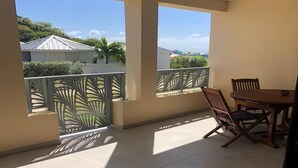 A balcony with a view of neighboring houses and greenery.