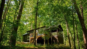 A cabin in a forest with a wooden deck and multiple levels. - Riverfront Home I Kayak & Fishing I 6 mins Mentone (Mentone)