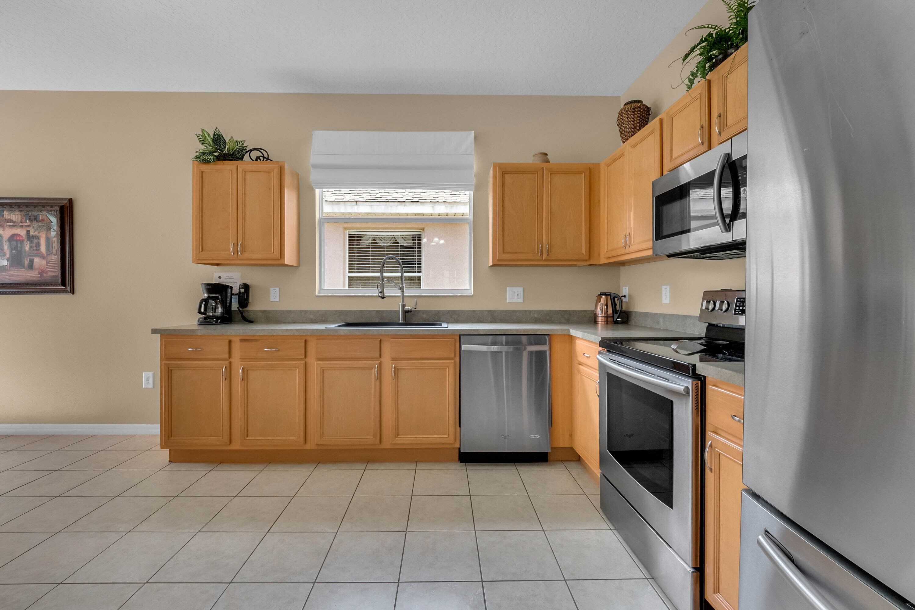 A modern kitchen with wooden cabinets, stainless steel appliances, and a dishwasher.