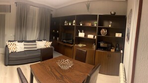 A modern living room with a dining area, a kitchen with a stone backsplash, and a view of the outside. - navas suite (Navas del Rey)
