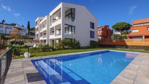 A modern building with a swimming pool, balconies, and a well-maintained garden. - X-3 Ground floor apartment in community with pool (Calella de Palafrugell)