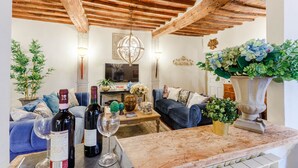Una sala de estar acogedora con techo de madera, un sofá, una mesa de centro y plantas decorativas.
