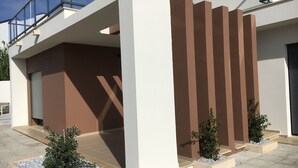 Un edificio moderno con techo plano, ventanas amplias y un balcón.