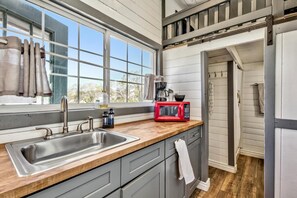 Fridge, microwave, coffee/tea maker, cookware/dishes/utensils