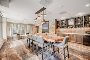 A modern kitchen with a large island, built-in appliances, and a stone accent wall.